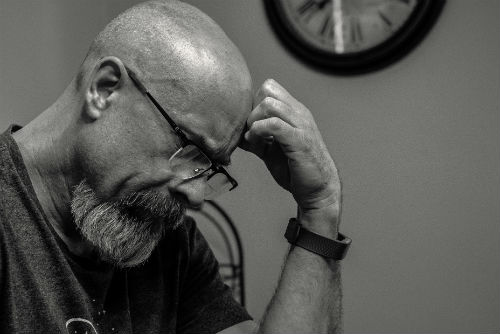 a man looking stressed while looking over his denied workers comp claim paperwork